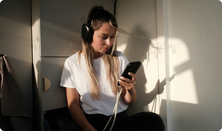Young land on phone with headphones